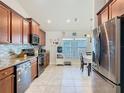 Well-lit kitchen featuring stainless steel appliances, tile backsplash, and tile flooring at 649 Meadow Pointe Dr, Haines City, FL 33844