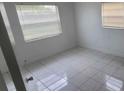 This bedroom features a white-tiled floor and two windows with white blinds at 717 Michigan Ct # 2, St Cloud, FL 34769