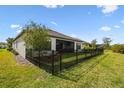 Spacious backyard with a black metal fence, green grass, and a covered screened patio at 937 Walnut Creek Ln, Poinciana, FL 34759