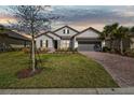 Inviting single-Gathering home with a brick driveway, well-maintained lawn, and neutral exterior paint at 937 Walnut Creek Ln, Poinciana, FL 34759