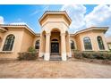 Elegant home featuring arched entryway, double front doors, manicured landscaping, and brick paved driveway at 11856 Vinci Dr, Windermere, FL 34786