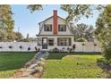 Quaint two-story home featuring a well-maintained front lawn and a charming white picket fence at 1205 Wisconsin Ave, St Cloud, FL 34769