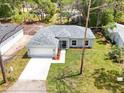 An aerial view of a single-story home with a well-manicured lawn and concrete driveway at 2033 10Th Ave, Deland, FL 32724