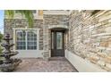 Inviting front entrance with brick accents, a decorative fountain, and an elegant front door at 2250 Windcrest Lake Cir, Orlando, FL 32824