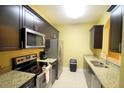 Galley kitchen with stainless appliances, granite countertops, and ample cabinet space at 2305 Silver Palm Dr # 102, Kissimmee, FL 34747