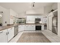 Bright kitchen with stainless steel appliances, white cabinets, and tile flooring, creating a clean and modern space at 248 Breezy Oaks Ct, Davenport, FL 33896