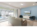Stylish living room with blue accent wall, modern furniture, and a view of the outdoor pool area at 281 Jetty Way, Davenport, FL 33897
