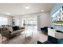 Bright living room with a view of the screened pool, featuring comfortable seating and modern decor at 281 Jetty Way, Davenport, FL 33897