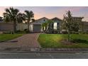 Inviting home with lush landscaping, brick driveway, and beautiful curb appeal at 309 Vestrella Dr, Poinciana, FL 34759
