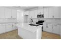 Bright, all-white kitchen showcases stainless appliances, quartz countertops, and a stylish center island at 3725 Deer Ridge Dr, Mount Dora, FL 32757
