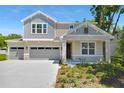 Inviting two-story home with a three-car garage and manicured landscaping under a clear blue sky at 3749 Deer Ridge Dr, Mount Dora, FL 32757