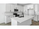 Modern kitchen featuring white cabinets, stainless steel appliances, and a center island at 3749 Deer Ridge Dr, Mount Dora, FL 32757