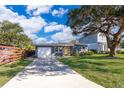 Charming single-story home with a well-maintained lawn, a light-grey exterior, and a patterned brick driveway at 4217 Park Lake St, Orlando, FL 32803