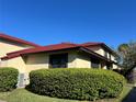 Exterior view of a charming home featuring a red tile roof and lush landscaping at 433 Hunter Circle Cir, Kissimmee, FL 34758