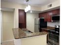 Kitchen featuring granite countertops, stainless steel appliances, and wood cabinets at 5160 Conroy Rd # 1414, Orlando, FL 32811