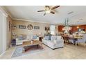Comfortable living room with neutral-toned sofas, tile flooring, and an open layout to the kitchen at 5457 Animosh Ct, Polk City, FL 33868