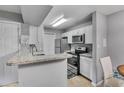 Bright kitchen with white cabinets, granite countertops, stainless steel appliances at 5530 Chrishire Way # D204, Orlando, FL 32822