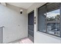 Close-up of condo unit door featuring number 58, window and surrounding light textured facade at 6 Escondido Cir # 58, Altamonte Springs, FL 32701