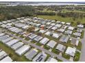 An aerial view of a well-maintained neighborhood, with a lake in the background, highlighting community living at 6475 Peppertree Ne Path, Winter Haven, FL 33881