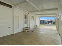 A spacious carport featuring a textured floor and an entrance to the home, offering convenient parking at 6475 Peppertree Ne Path, Winter Haven, FL 33881