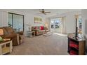 Bright living room with neutral carpet, plush seating, and large windows, creating an inviting space at 6475 Peppertree Ne Path, Winter Haven, FL 33881