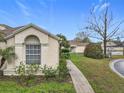 Well-kept home featuring desert landscaping, concrete walkway, and covered porch at 734 Olympic Cir # 30, Ocoee, FL 34761