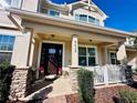 Inviting front porch with stone accents, flower pots, and cozy seating area at 8628 Dufferin Ln, Orlando, FL 32832