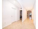 Bright hallway featuring neutral paint, tile flooring, and arched doorways that lead into various rooms of the home at 9012 Tuscan Cypress St, Kissimmee, FL 34747