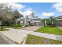 Charming single-story home with a well-manicured lawn, a brick walkway, and a three car garage at 11454 Wakeworth St, Orlando, FL 32836