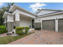 Charming single-story home featuring a brick paver driveway, a well-manicured lawn and a three car garage at 11454 Wakeworth St, Orlando, FL 32836
