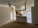 Open-concept living room with neutral walls and vaulted ceiling flows into the kitchen at 138 Inconnu Ct, Kissimmee, FL 34759