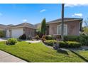 Charming single-story home with a manicured front lawn, mature landscaping, and decorative accents at 141 Prestwick Dr, Davenport, FL 33897