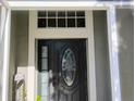 Close up of front door featuring decorative leaded glass and sidelight framed in white trim at 250 Sir Phillips Dr, Davenport, FL 33837