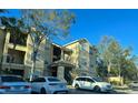 Apartment building featuring balconies and visible parking for residents and visitors at 2558 Robert Trent Jones Dr # 1412, Orlando, FL 32835