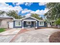 Charming blue home with a brick-accented driveway and well-maintained landscaping at 2919 Sylvan Ave, Orlando, FL 32806