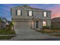 Exterior of a two-story home showcasing neutral colors, dark shutters, an attached garage and well-manicured landscaping at 293 Pineywoods St, St Cloud, FL 34772