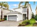 Modern two-story home featuring a two-car garage, neutral paint, second-story balcony, and manicured landscaping at 301 Pendant Ct, Kissimmee, FL 34747