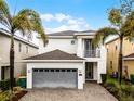 Modern home with neutral paint, second-story balcony, gray garage door, pavers, and professional landscaping at 301 Pendant Ct, Kissimmee, FL 34747
