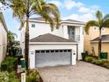 Modern home with neutral paint, gray garage door, professional landscaping, pavers, and an inviting front entrance at 301 Pendant Ct, Kissimmee, FL 34747