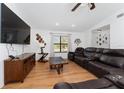 Comfortable living room with wood flooring, a large TV, and a plush leather sectional at 3189 Saint James Ave, Deltona, FL 32738