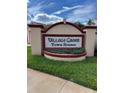 Entrance sign to Village Green Town Houses with landscaping in a well-maintained neighborhood at 3449 Village Green Ct, St Cloud, FL 34772