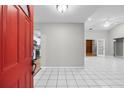 Inviting entryway with a bright red door and tiled flooring offers a glimpse into the home's interior at 4172 Stonehenge Rd, Mulberry, FL 33860