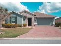 Inviting single-Gathering home featuring stone accents, a brick driveway, and manicured landscaping at 461 Treviso Dr, Kissimmee, FL 34759