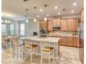Modern kitchen with stainless steel appliances, quartz countertops, and ample cabinet space, flowing into the dining area at 461 Treviso Dr, Poinciana, FL 34759
