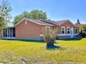 Exterior view of home highlighting a spacious yard and screened in lanai for outdoor enjoyment at 602 N Delmonte Ct, Kissimmee, FL 34758