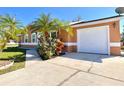A well-maintained home featuring a garage with white door and palm tree in the front yard at 602 N Delmonte Ct, Kissimmee, FL 34758