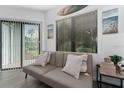 Bright living room featuring a sofa, artwork, large window, and sliding glass door to the patio at 6165 Carrier Dr # 2108, Orlando, FL 32819