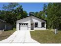 Charming single Gathering home boasts a modern exterior with a paved driveway and an attached garage at 6862 Se 23Rd Ave, Ocala, FL 34480