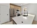 Modern kitchen features stainless steel appliances and a large island with a quartz countertop at 6862 Se 23Rd Ave, Ocala, FL 34480