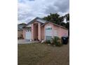 Exterior view of home with garage, large window, and manicured lawn at 7143 Edgewater Shores Ct, Orlando, FL 32810